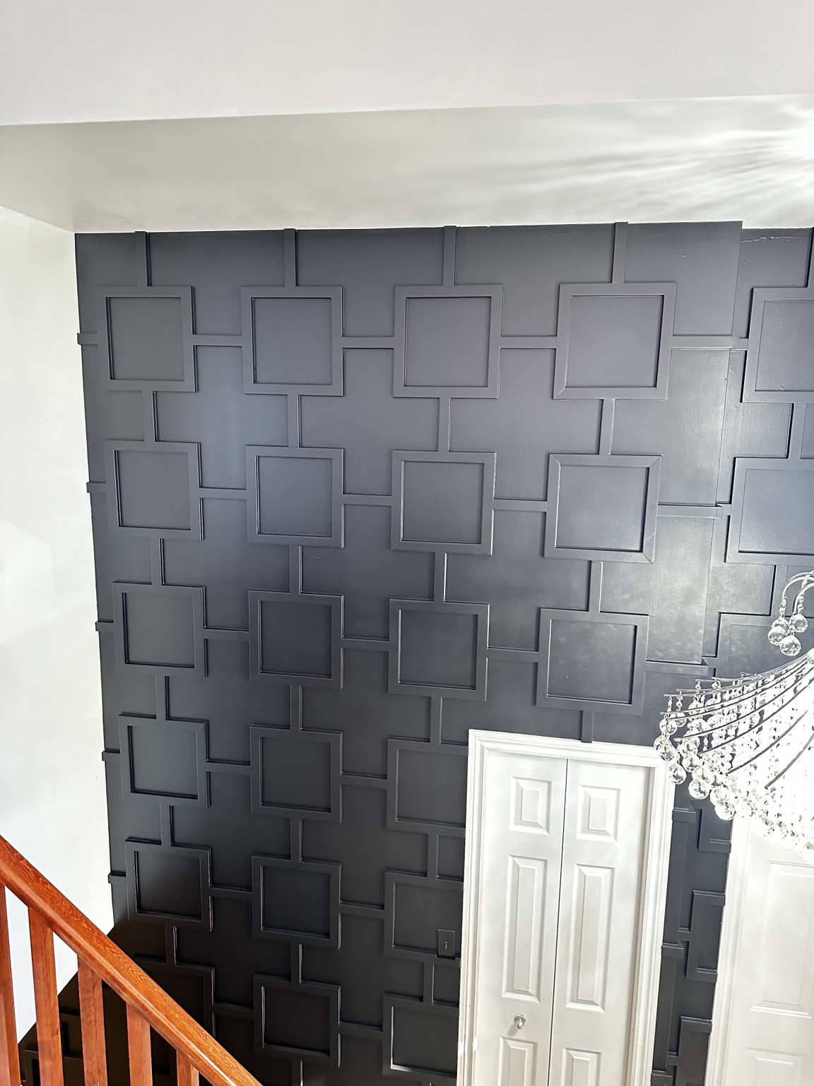 Dark geometric feature wall by a staircase