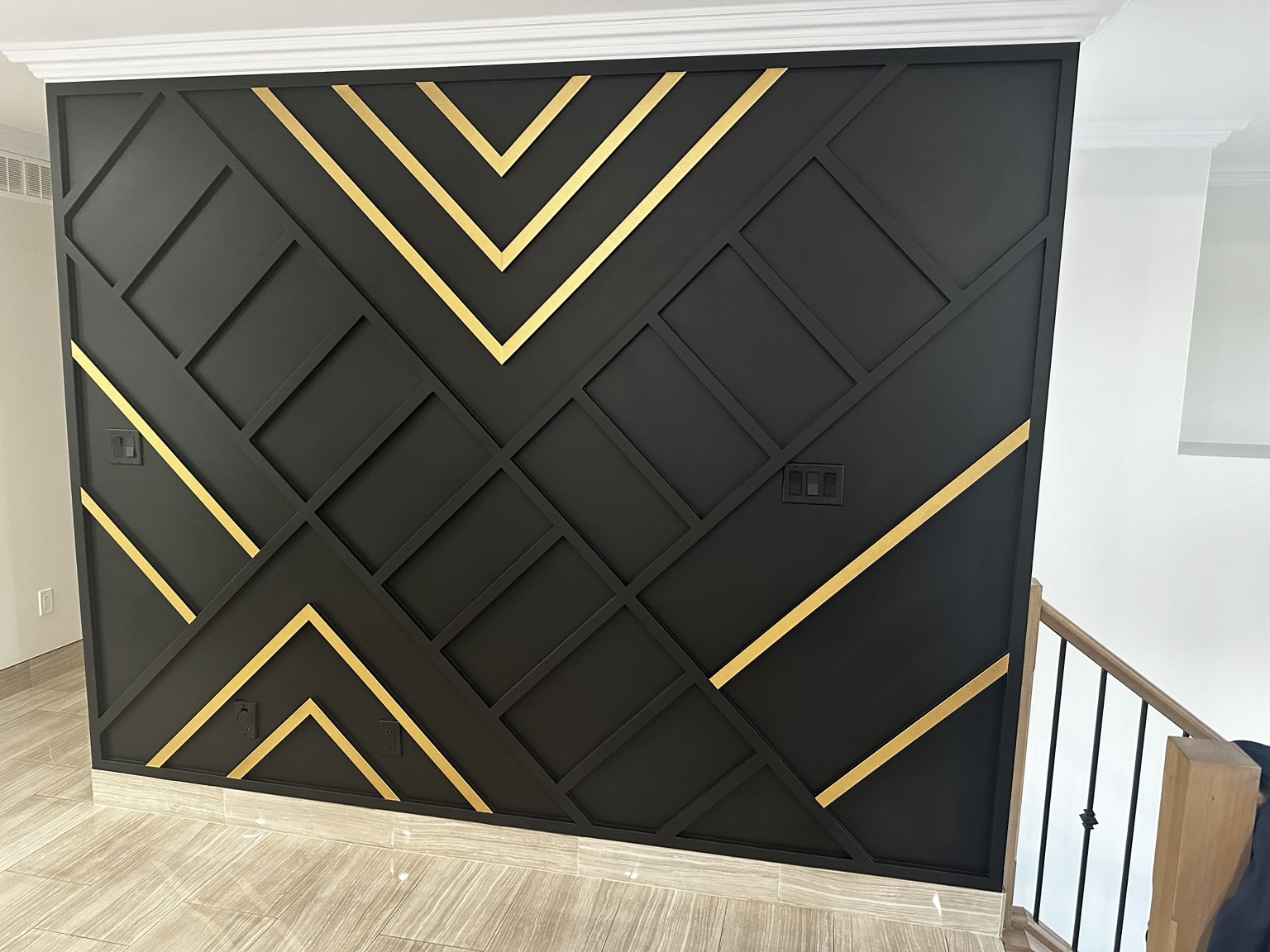 Black geometric wall with gold accents
